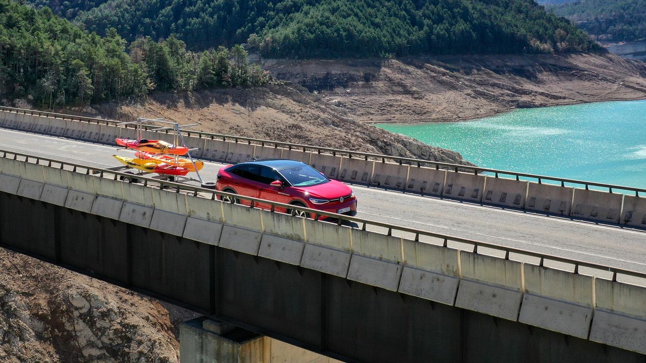 Ein roter ID.5 GTX fährt mit einem Anhänger über eine Brücke