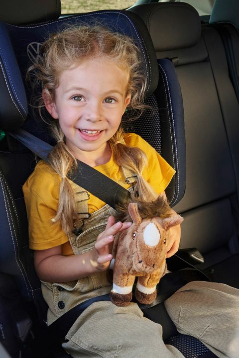 Ein Mädchen sitzt in einem Volkswagen Kindersitz